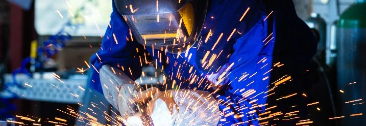 Person beim Schweißen mit Schutzkleidung